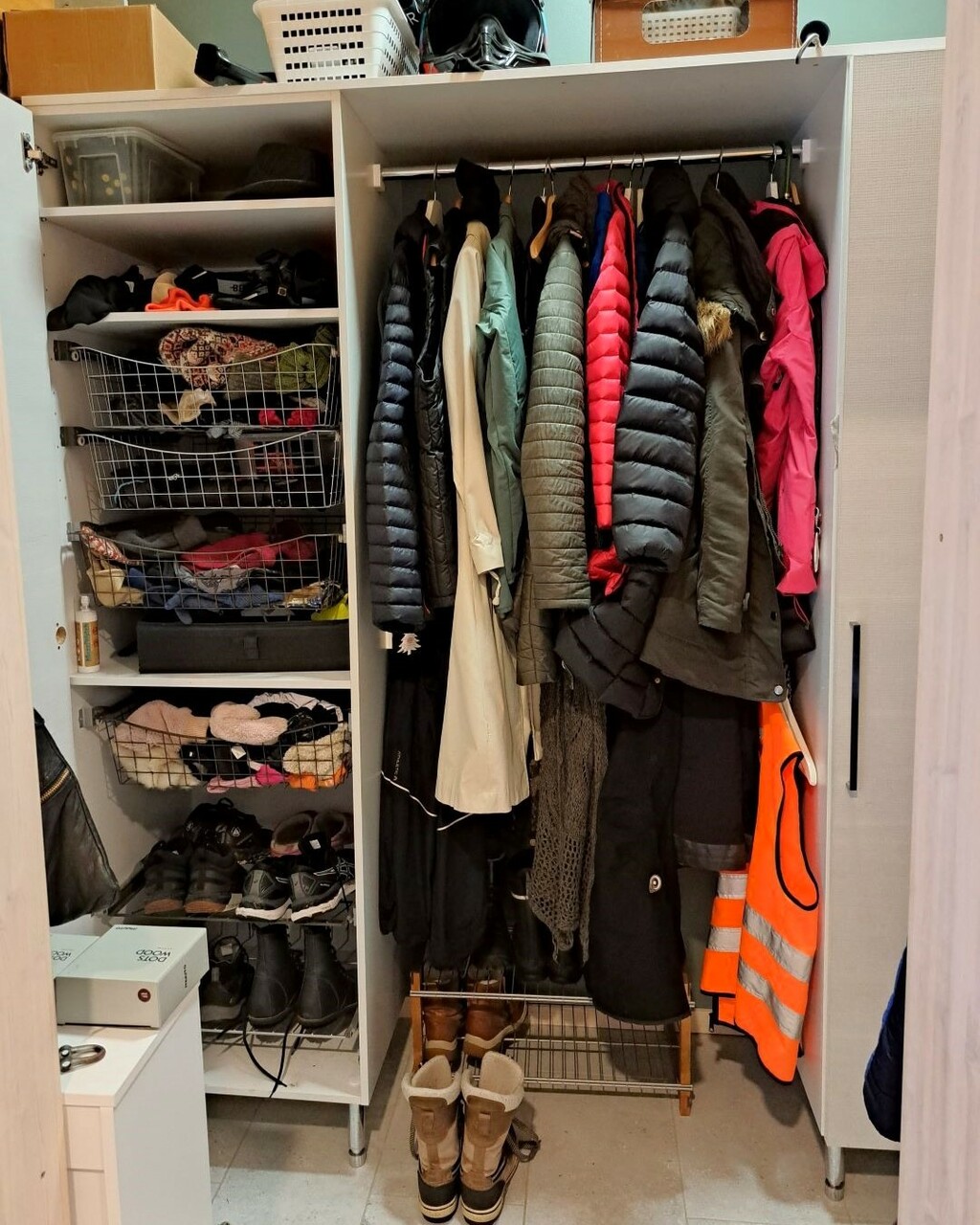 Lapsiperheen arkieteisen kaapit ovat täynnä eri vuodenaikoina käytettäviä ulkovaatteita ja asusteita. Myös kaapin päällä on sekalaista tavaraa.