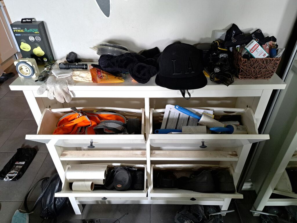 Eteisen kenkäkaappi on täynnä sekalaista tavaraa.